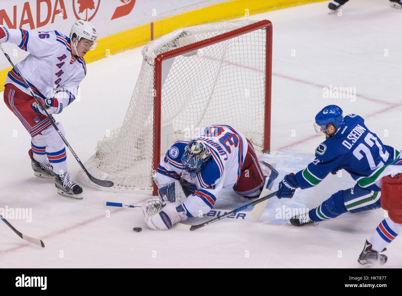 Canuck Daniel Sedin a caccia di un puck allentata nella parte anteriore del Goalie Henrik Lundqvist del New York Rangers, Rogers Arena Vancouver British Columbia. Foto Stock