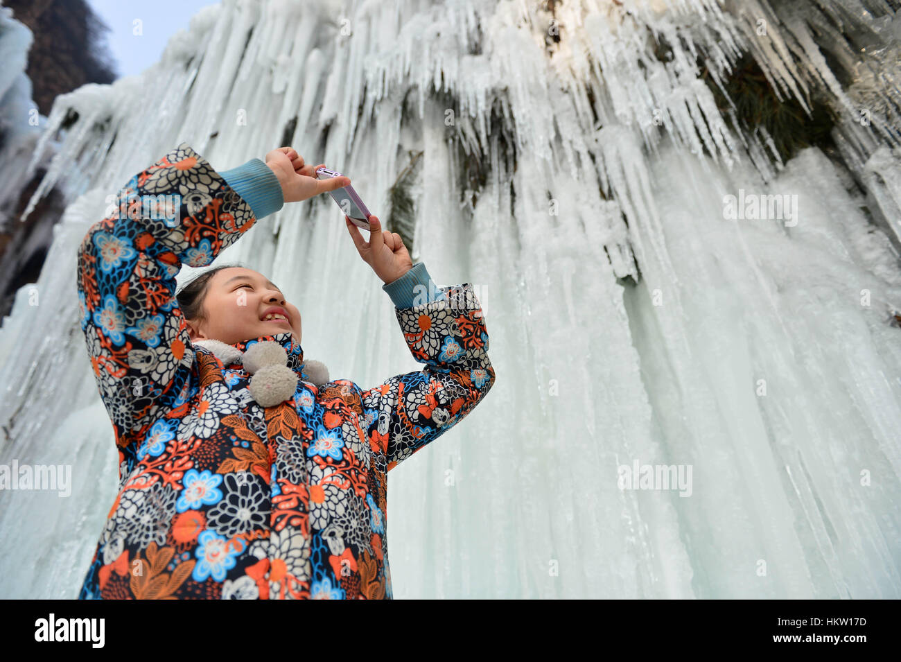 Xingtai. 30 gen, 2017. Un bambino prende le foto ad una cascata ghiacciata in un resort di Xingtai città del nord della Cina di nella provincia di Hebei, Gennaio 30, 2017. Credito: Mu Yu/Xinhua/Alamy Live News Foto Stock