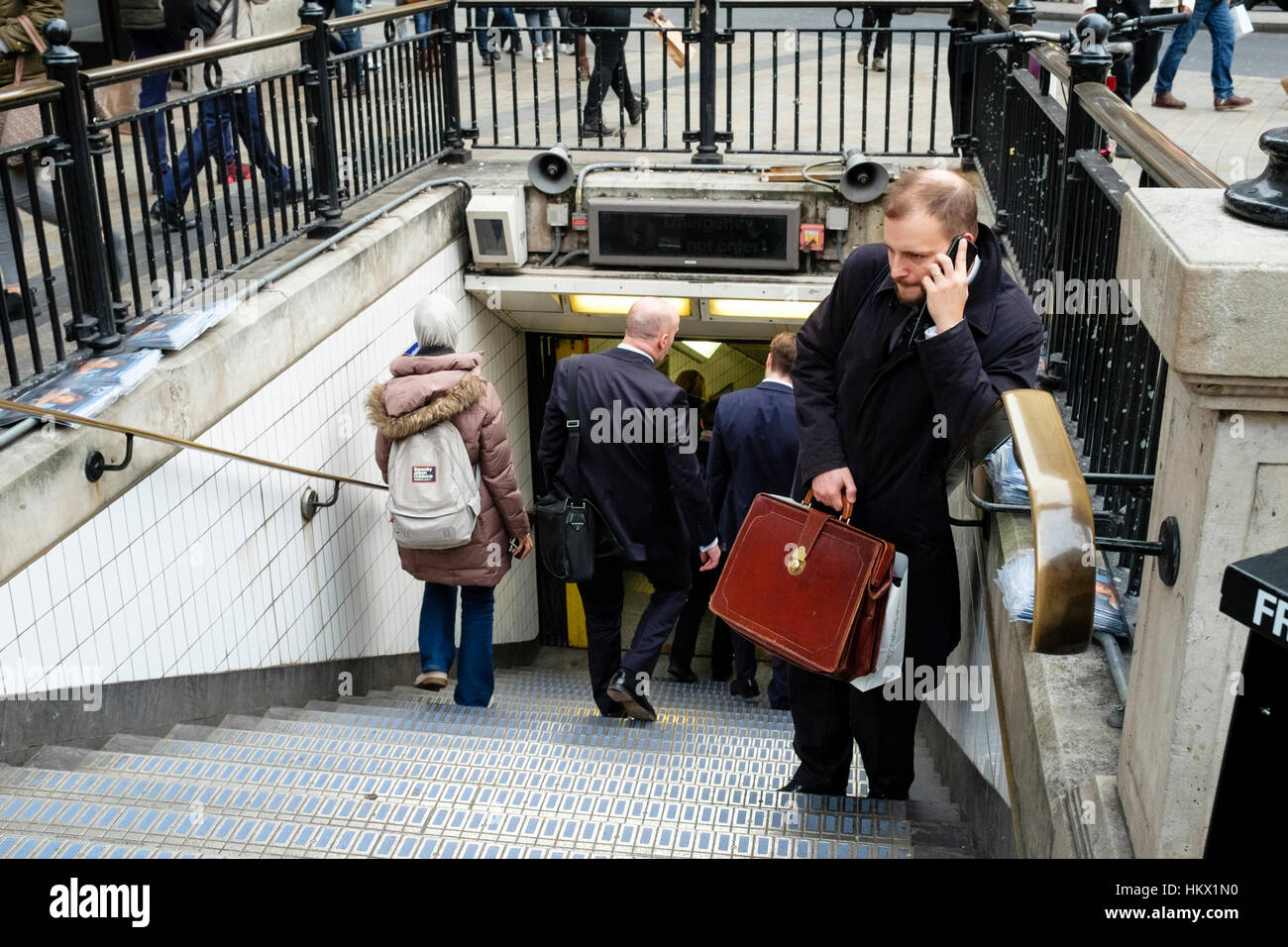Uomo con valigetta in pelle parla al telefono cellulare in entrata a Oxford Circus la stazione della metropolitana di Londra. Regno Unito Foto Stock