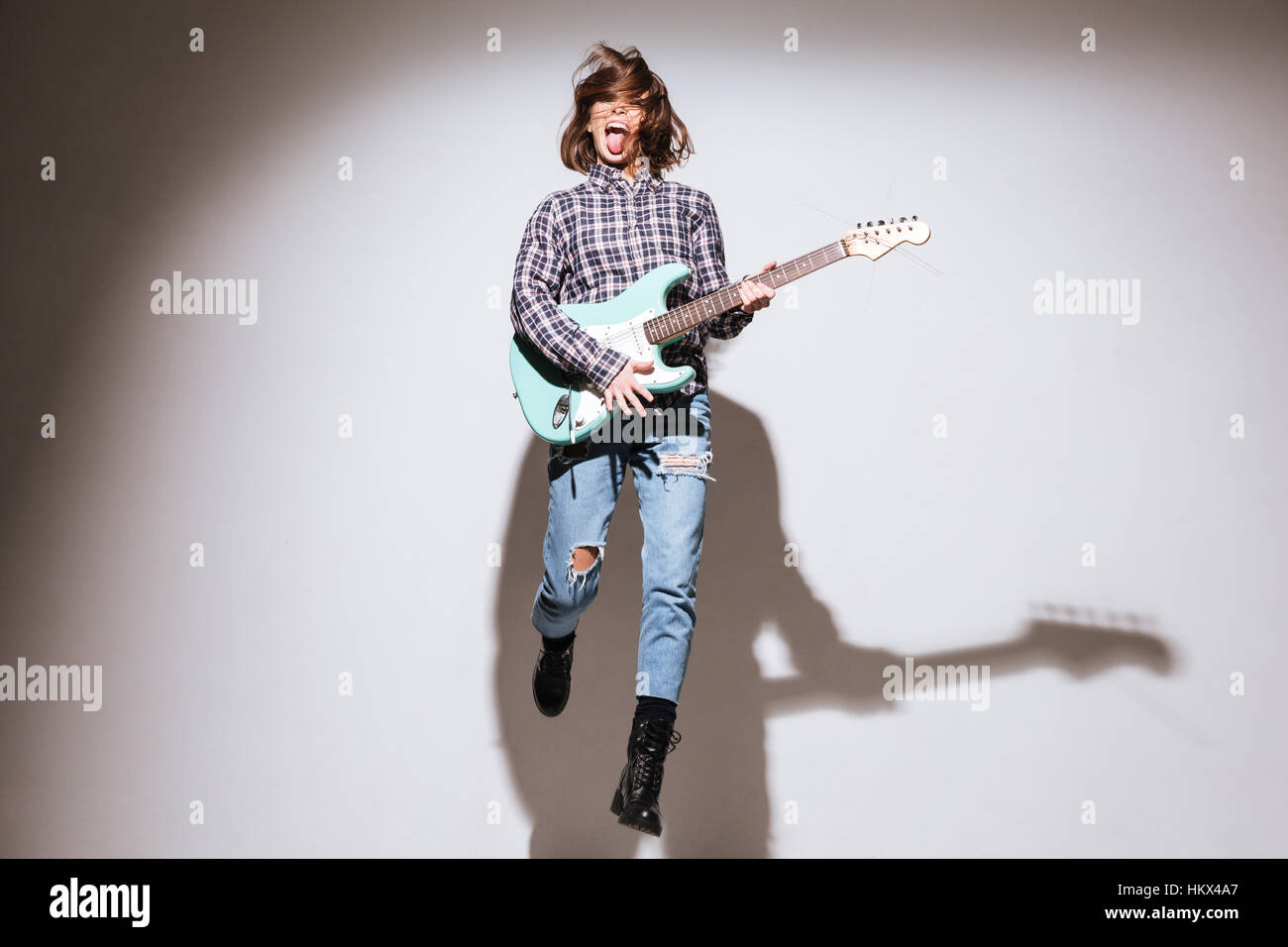 Profilo del giovane rosso in jeans che cammina e che porta chitarra  acustica. Corpo intero isolato su sfondo bianco Foto stock - Alamy
