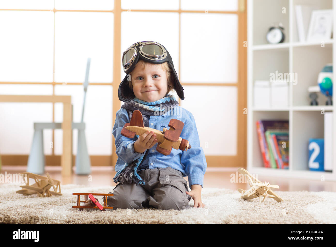 Capretto felice toddler giocando con aeroplano giocattolo e sogna di diventare un pilota Foto Stock