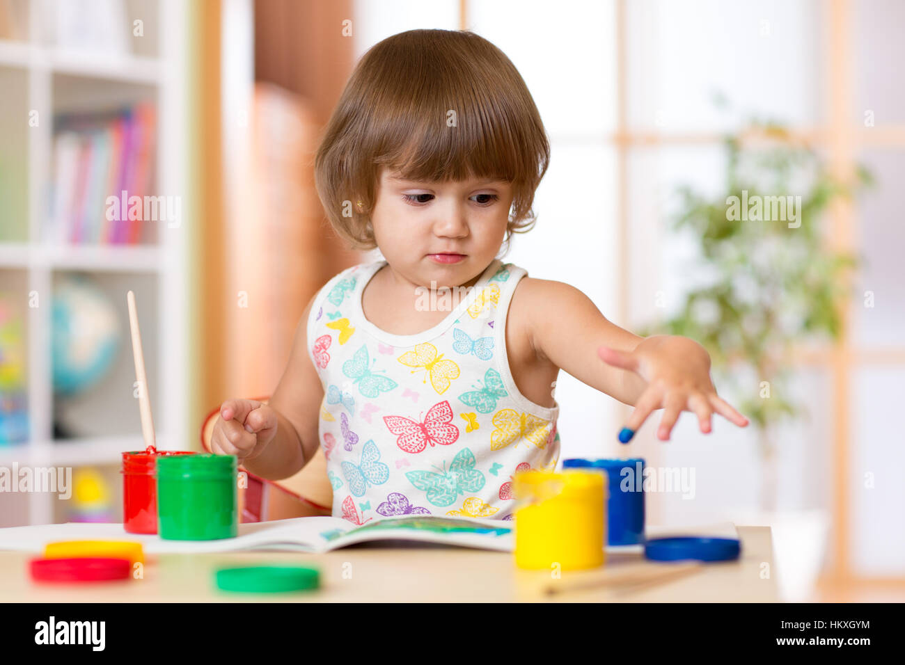 Bambino Cute girl pittura le dita in colori luminosi Foto Stock