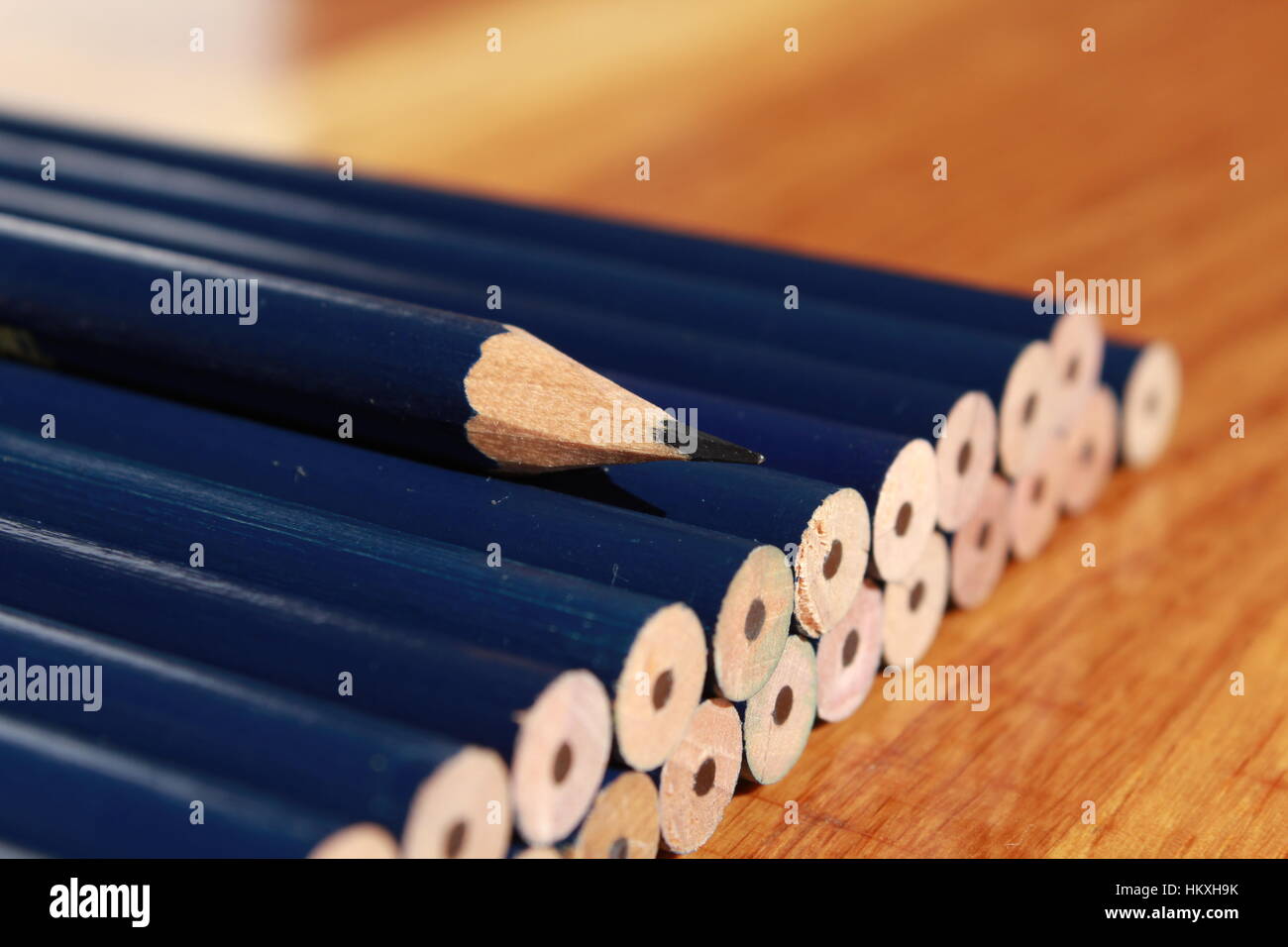 Una matita appuntita su una pila di blunt matite Foto Stock