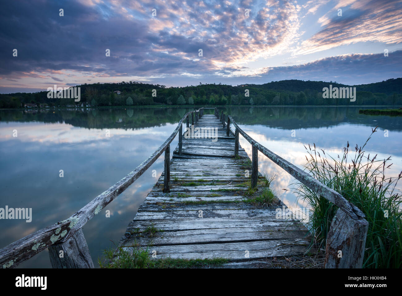 Il vecchio molo in legno su un lago di sunrise Foto Stock