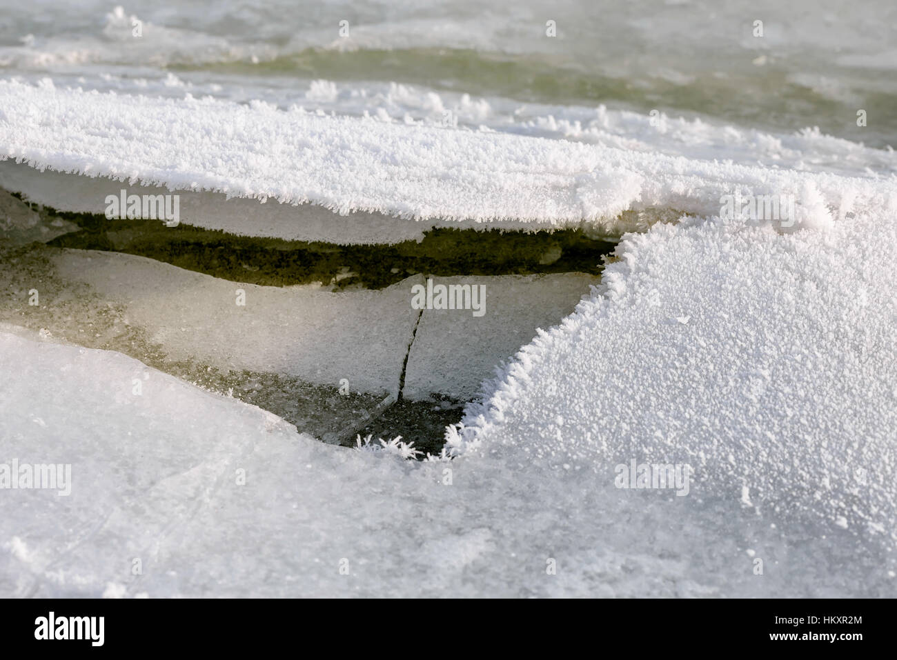Rotto il ghiaccio sul fiume durante un inverno freddo sotto il soft sole serale Foto Stock