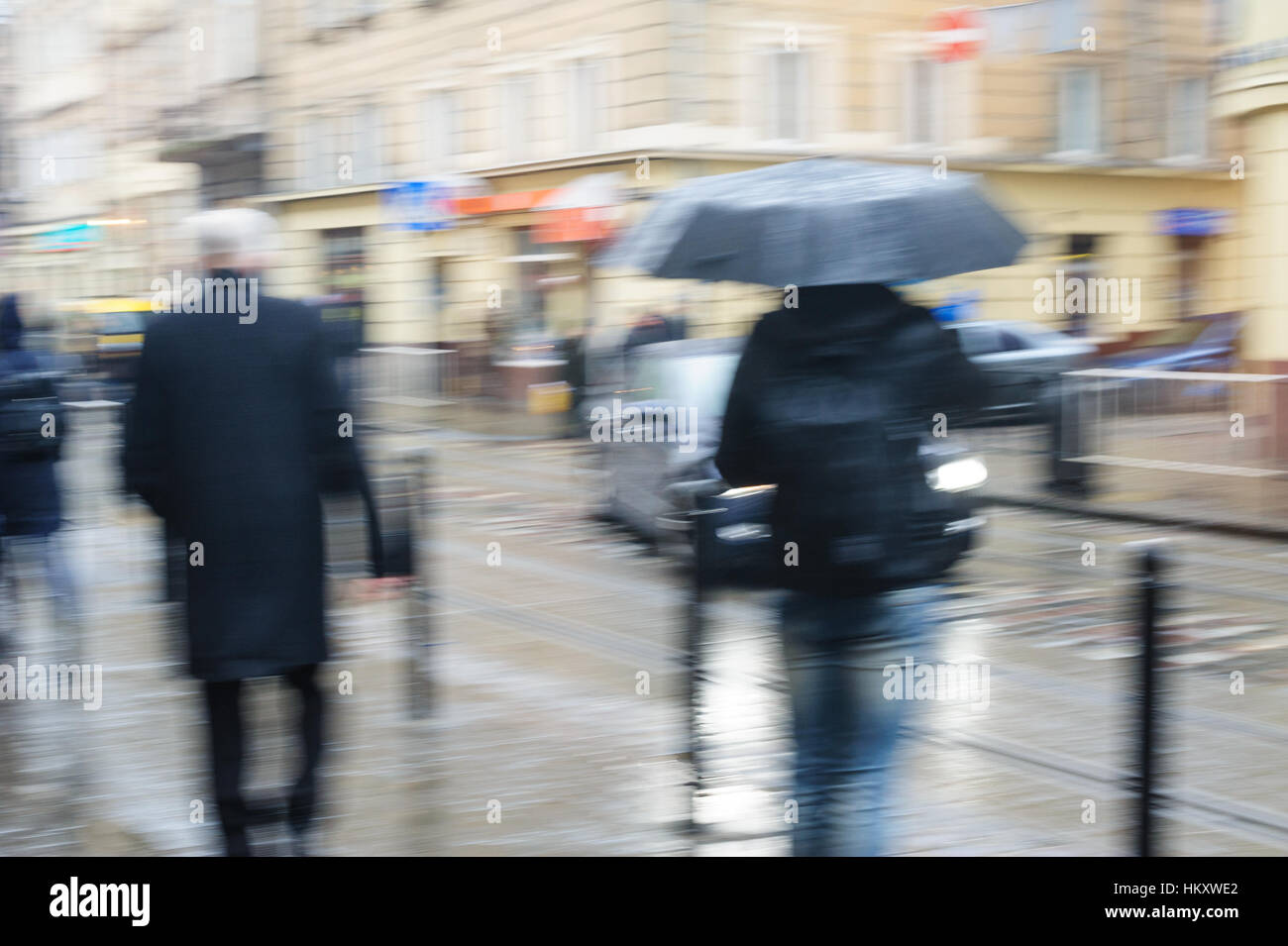 La gente a piedi giù per la strada di pioggia. sfocato focus Foto Stock