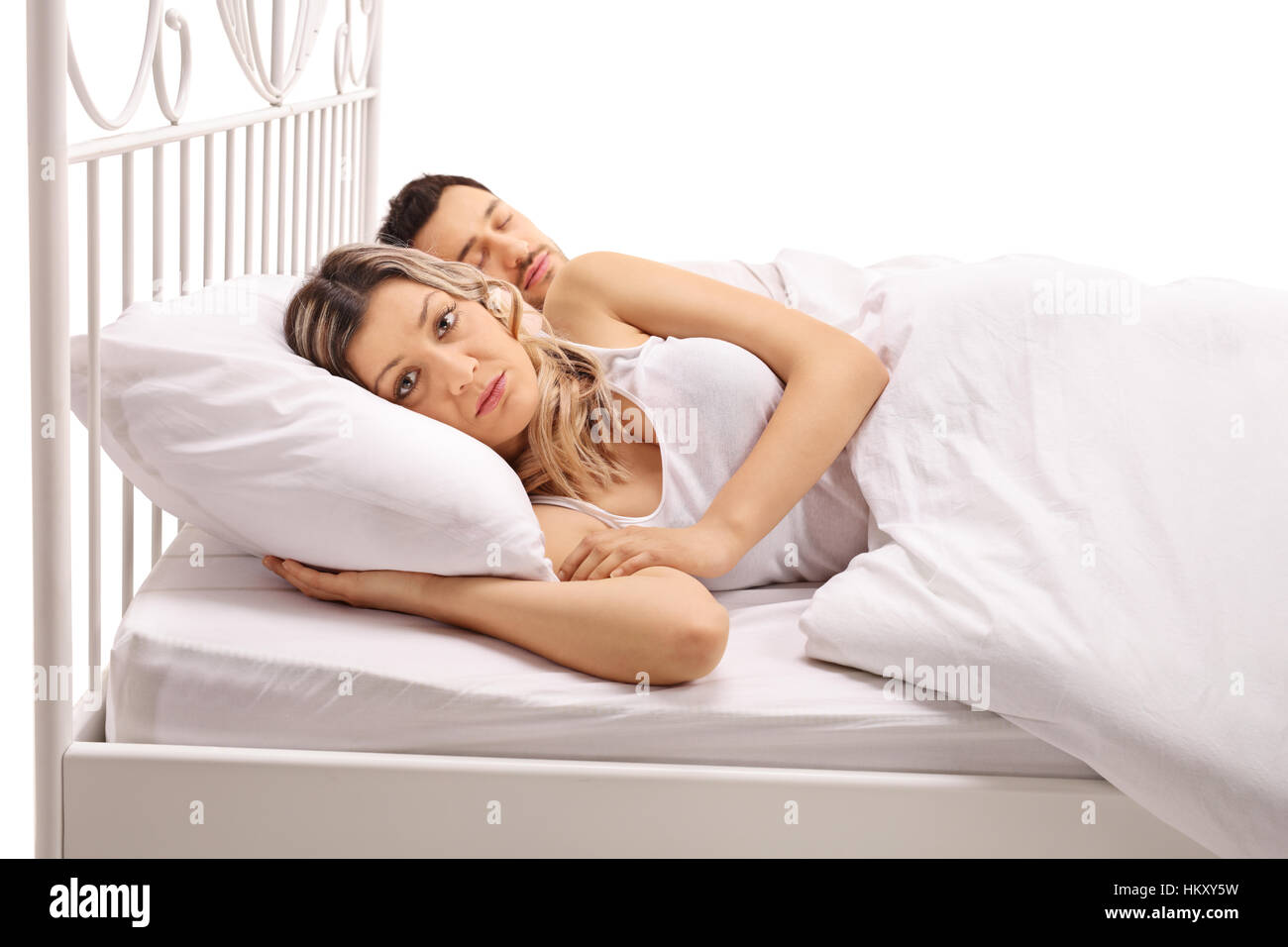 Preoccupato donna giaceva a letto con un ragazzo di dormire vicino al suo  isolato su sfondo bianco Foto stock - Alamy