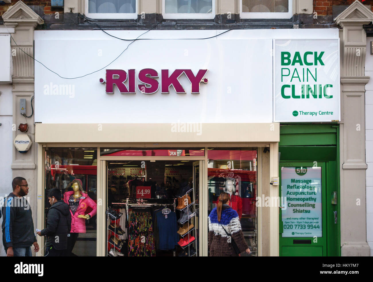 Due negozi a South London street con ingannevoli o confondere i segni - "rischiose dolore alla schiena clinic" Foto Stock