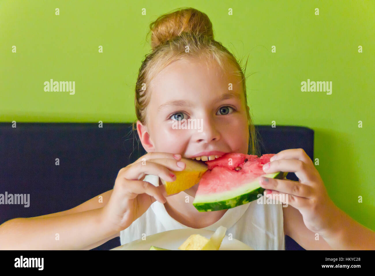 Foto della cute girl mangiando anguria e melone Foto Stock