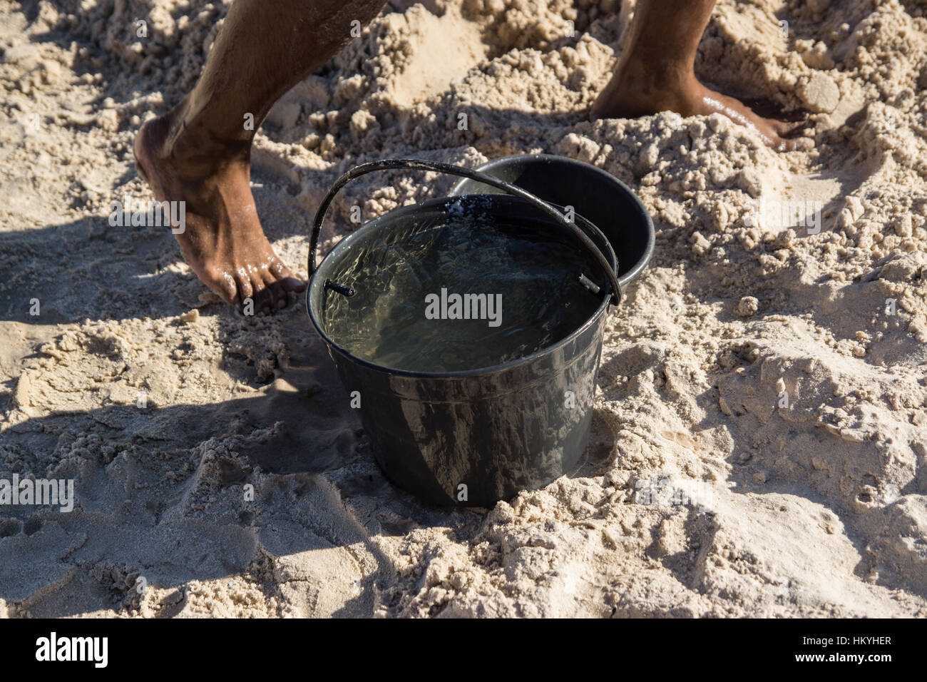Lama de agua en la playa con pies mojados Foto Stock
