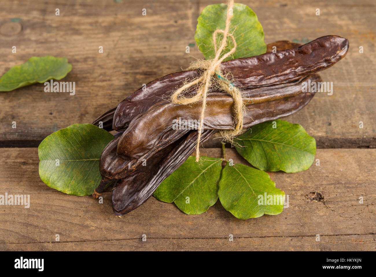 Materie frutti carruba sul vecchio sfondo di legno Foto Stock