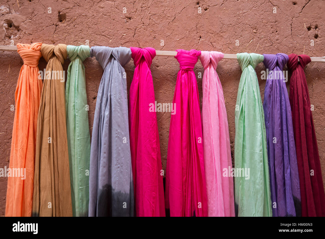 Foulard colorati appesi contro di terracotta con parete di fango Foto Stock