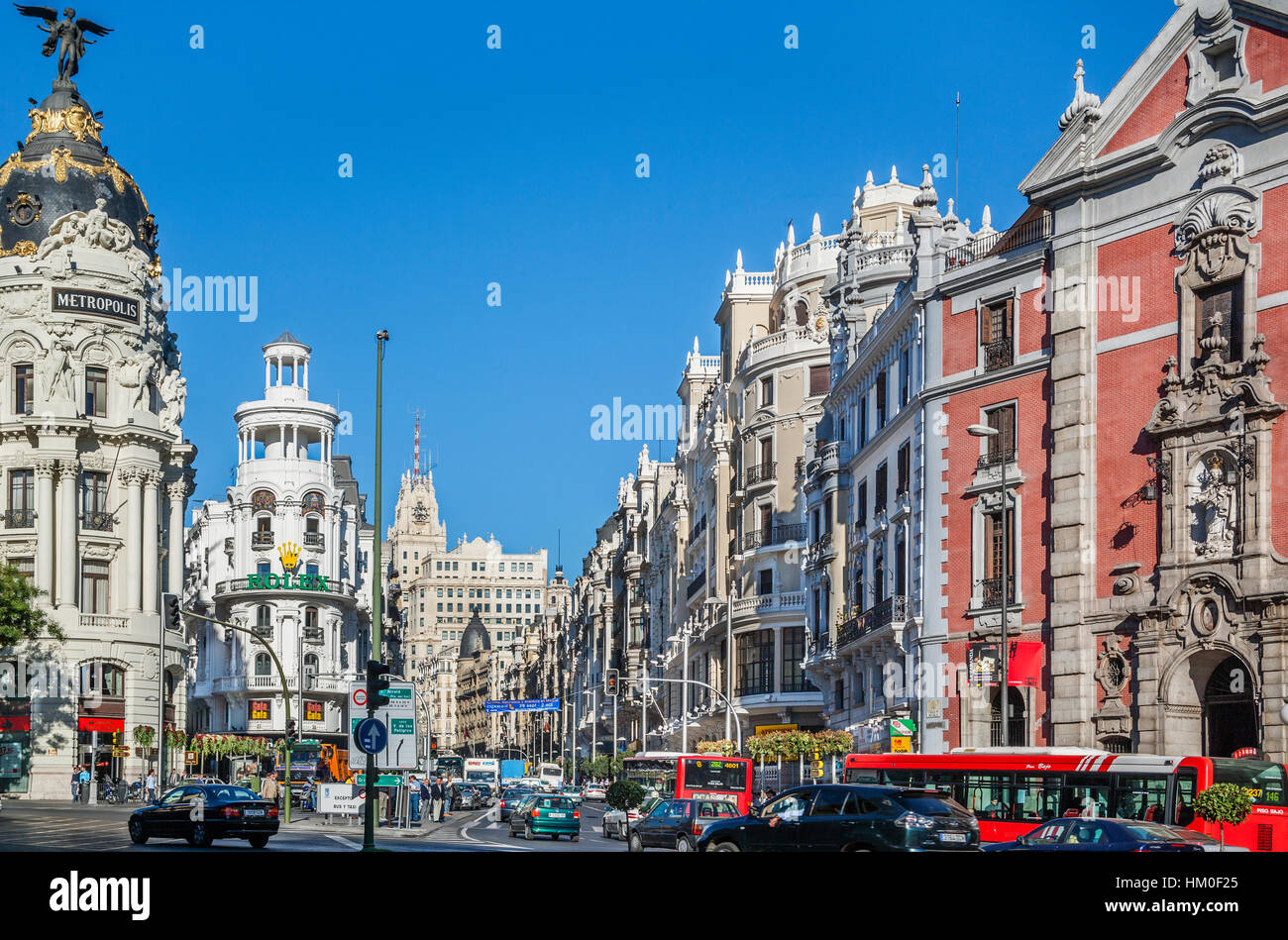 Spagna, Madrid, Centro incrocio occupato di Gran Via e Calle Alcalár con Edificios metropoli e erbose e la prominente facciata ornamentale di Igl Foto Stock