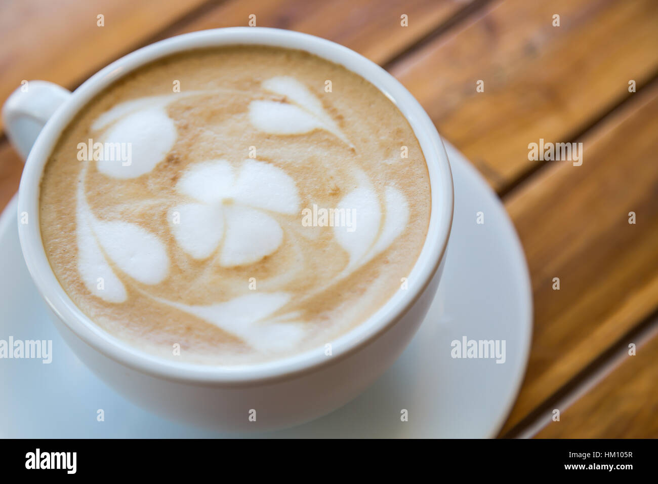 Tazza di caffè con modello cuore in una tazza bianca sulla tavola di legno Foto Stock