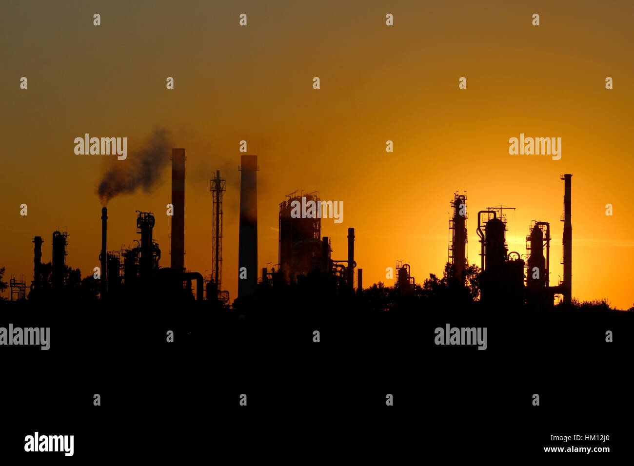 Silhouette di grande raffineria di petrolio fabbrica durante il tramonto Foto Stock