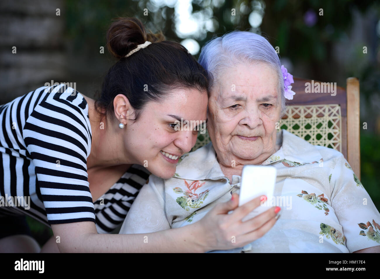 La nonna di prendere foto con i nipoti sul telefono bianco Foto Stock