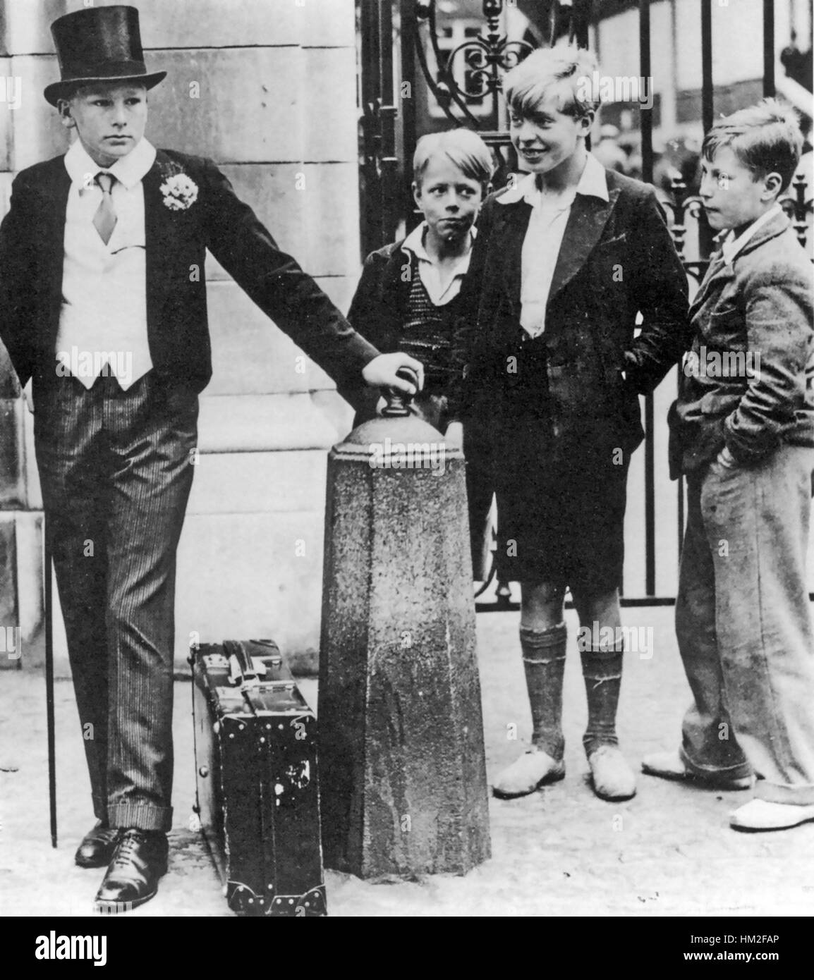 Il Lords Cricket Ground, London, Giugno 1937. Un allievo di Harrow attende il suo trasporto al di fuori del famoso cancelli sorvegliato da alcuni ragazzi locali. Foto Stock