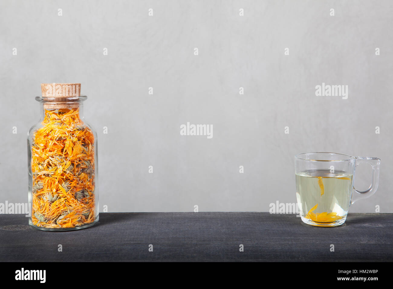 Calendula cantato in una bottiglia di vetro e la tazza di tè. Foto Stock