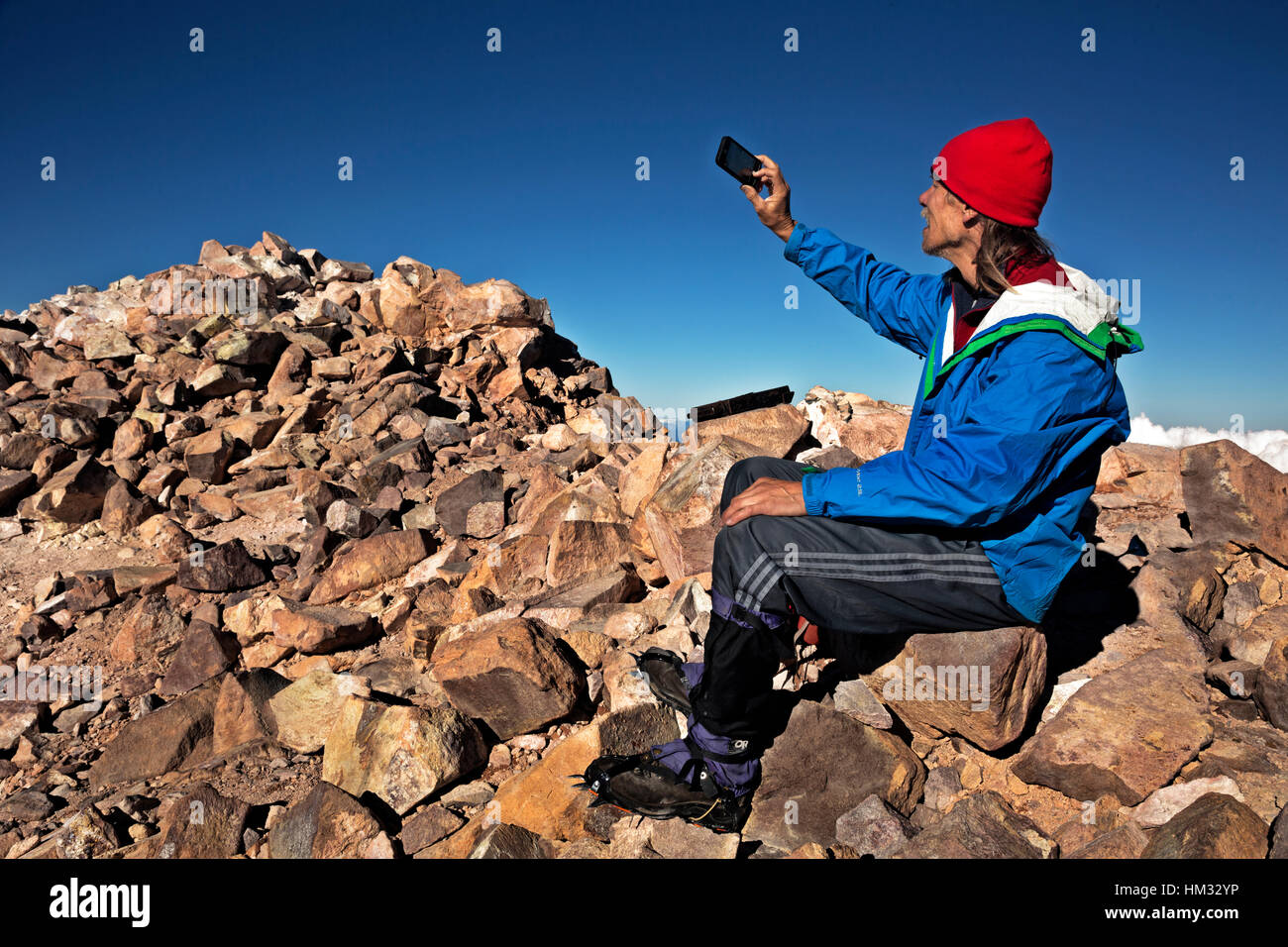 CA02940-00...CALIFORNIA - scalatore su 14,179 piedi di Cima del Monte Shasta nel Monte Shasta Wilderness area tenendo un selfie. Foto Stock