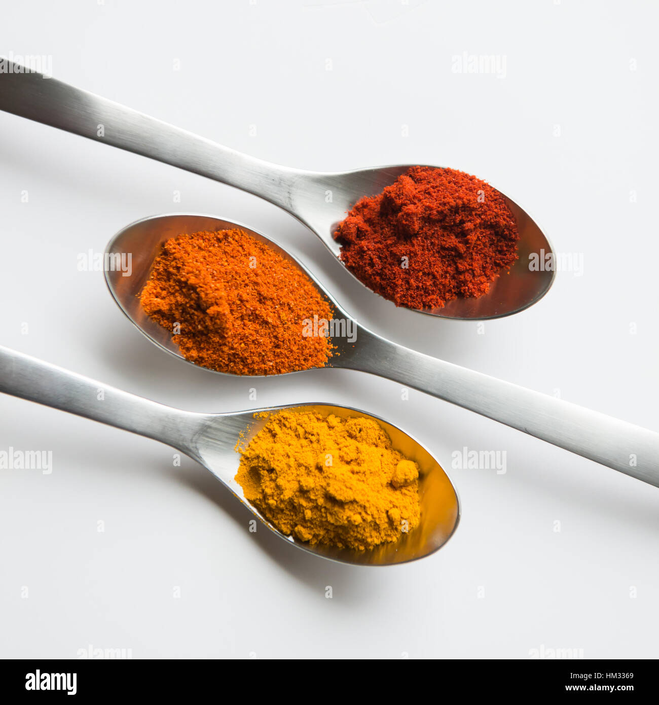 La curcuma, pepe di Caienna e paprica polveri di spezie in cucchiai di  metallo su bianco Foto stock - Alamy