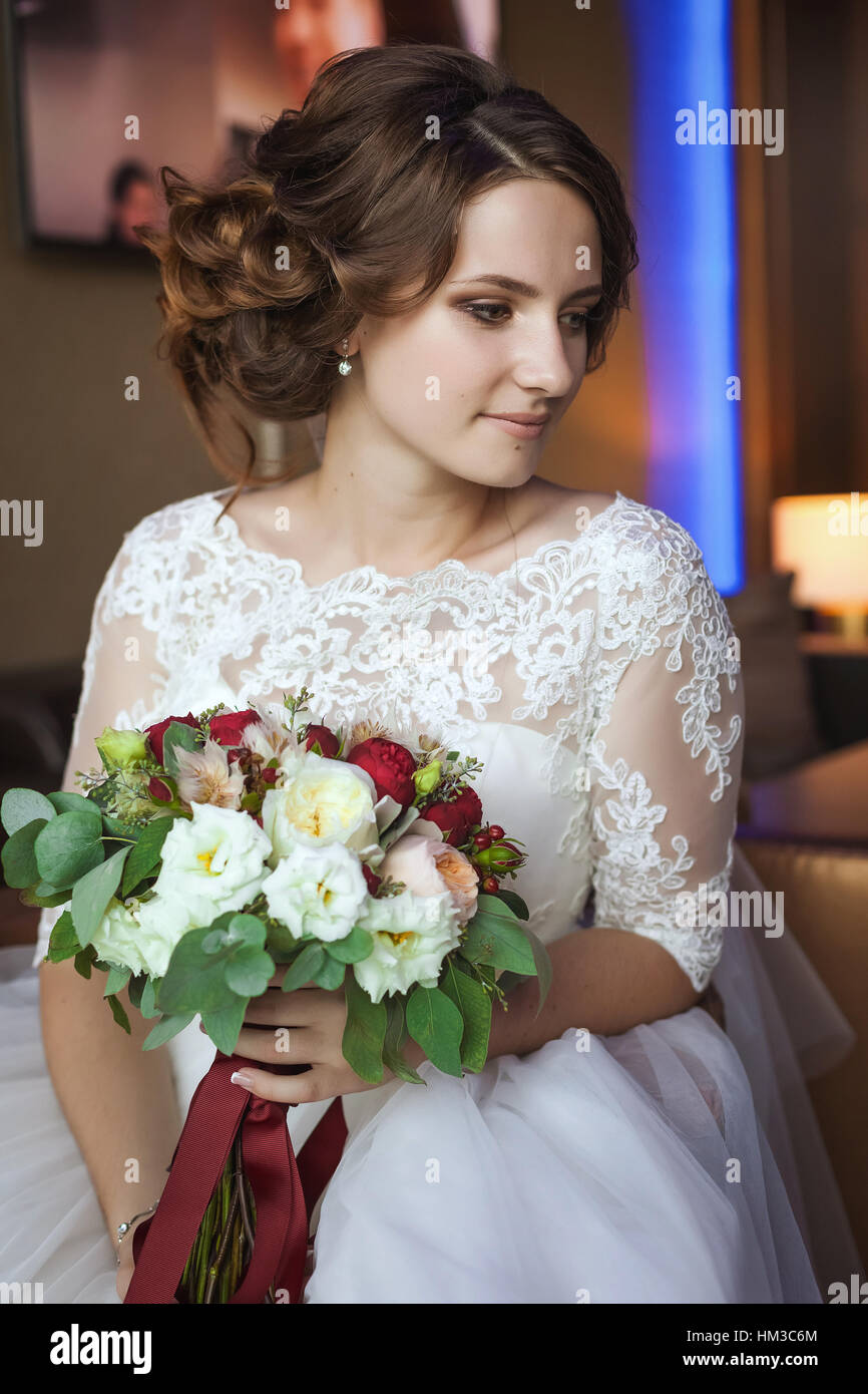 Elegante sposa in posa con bouquet su sfondo di foresta, lusso nozze boho Foto Stock