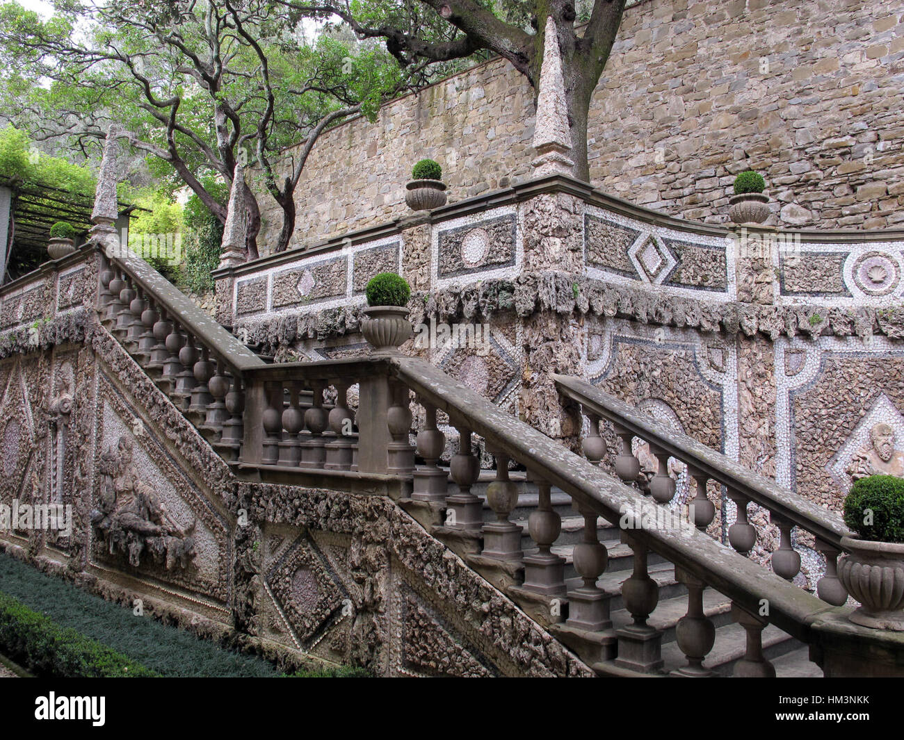 "Le Balze, Ninfeo 11" è un pezzo che rappresenta una scena di giardini all'italiana, incentrato su un elemento d'acqua chiamato ninfeo, una struttura architettonica classica spesso utilizzata nei giardini. L'opera d'arte ritrae la bellezza della natura e l'armonia tra architettura e ambiente. Foto Stock