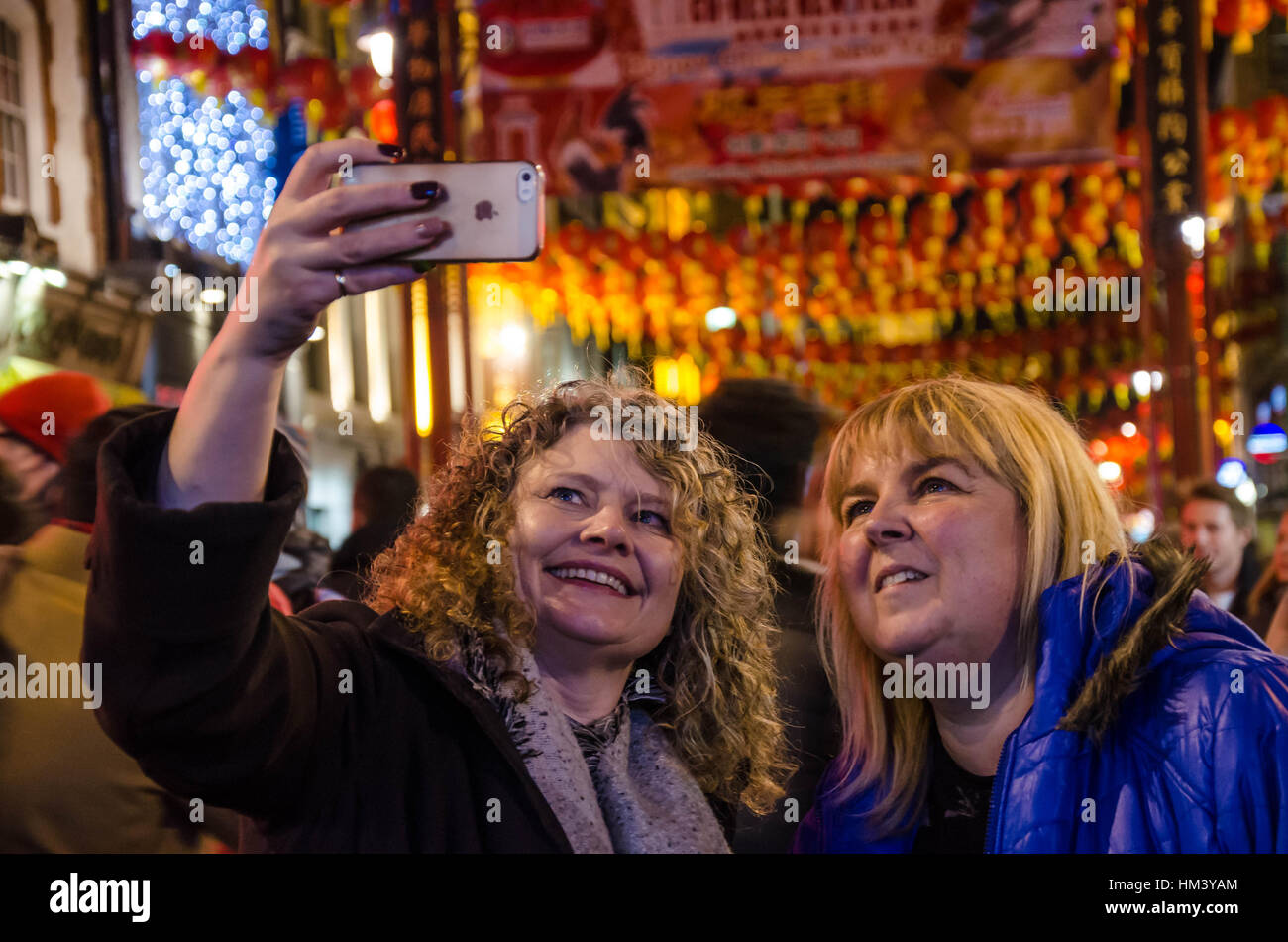 I turisti prendono un selfie in China Town, Londra la sera di Capodanno cinese. Foto Stock