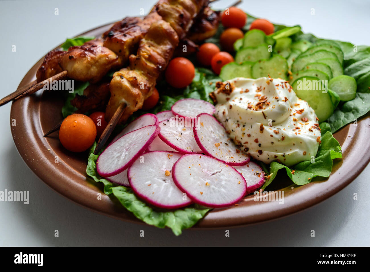 Spiedini di pollo con le verdure su una piastra di argilla Foto Stock