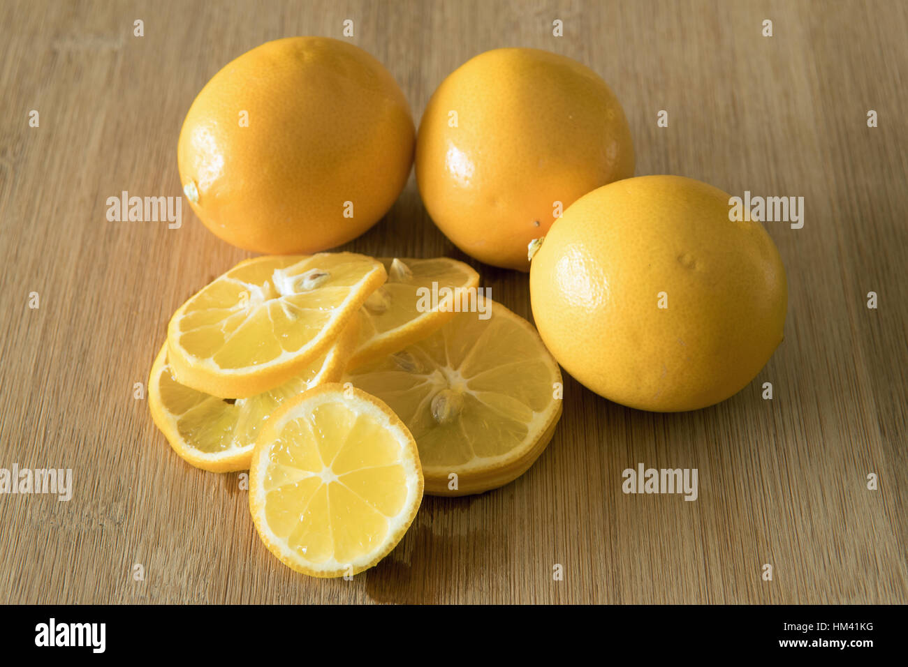Affettato e unsliced limoni sul bordo di taglio Foto Stock