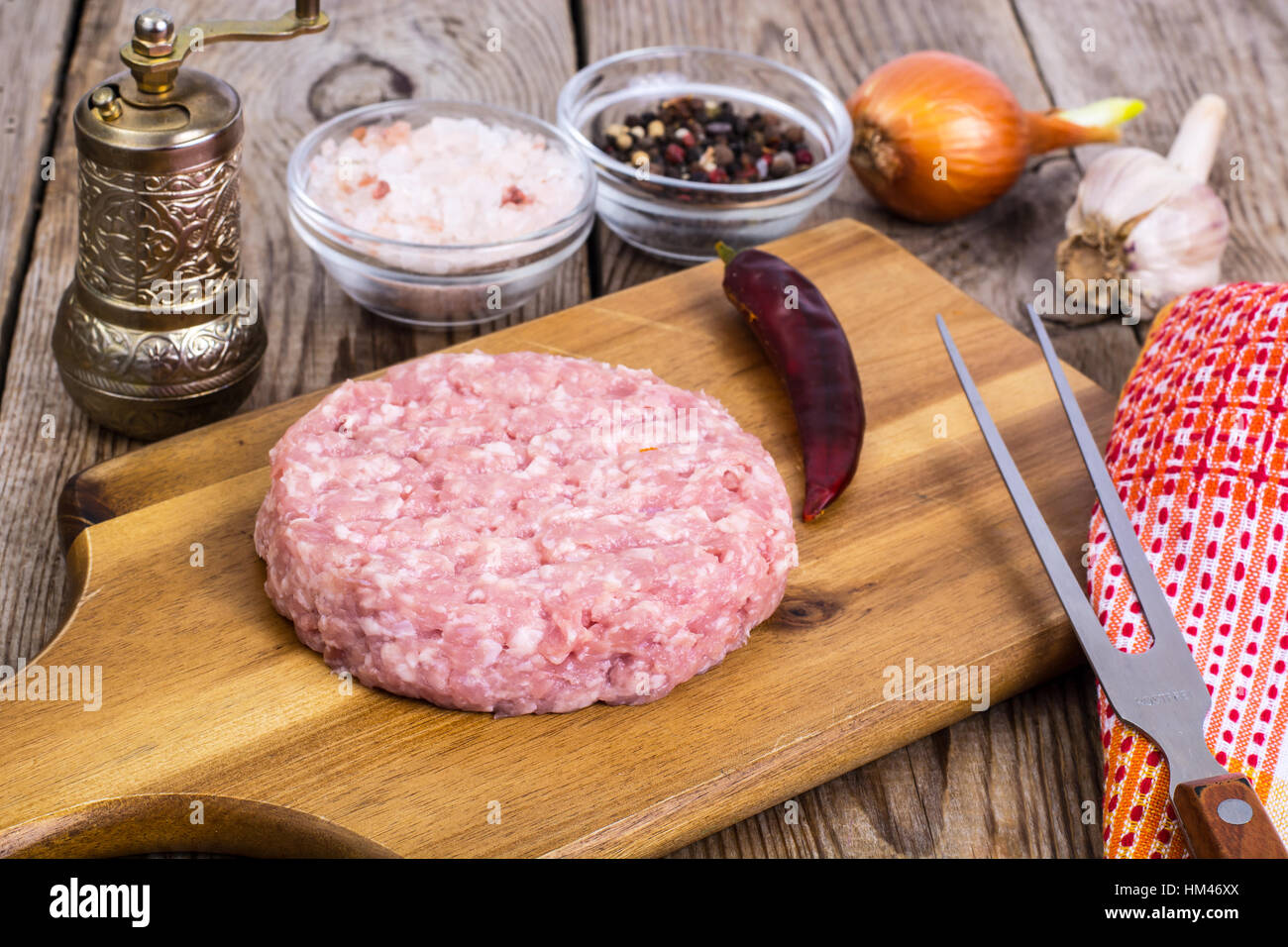 Carni macinate per la cottura di hamburger sul pannello di legno Foto Stock