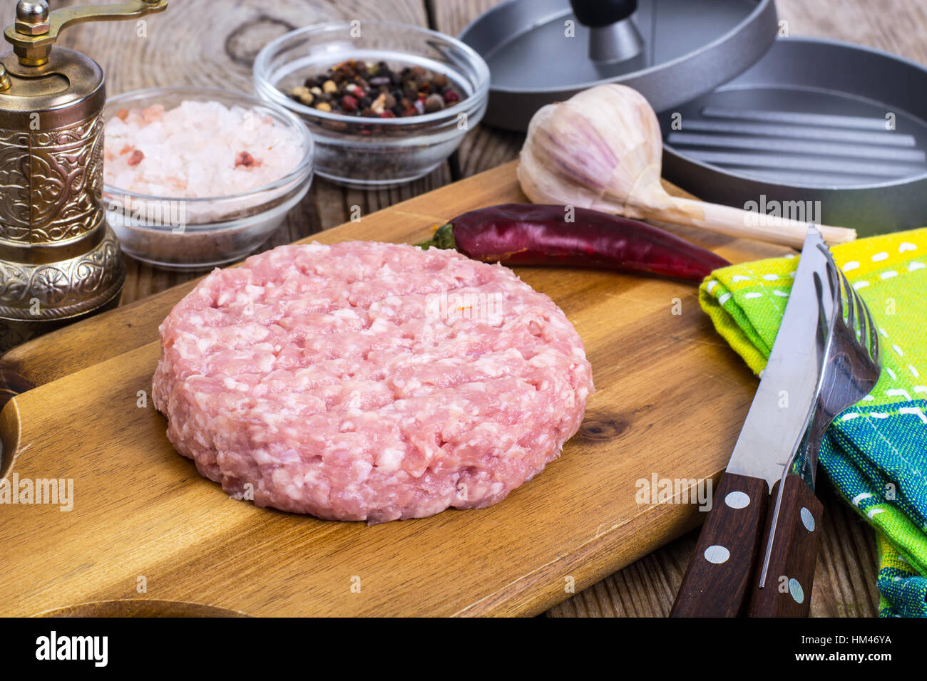 Carni macinate per la cottura di hamburger sul pannello di legno Foto Stock