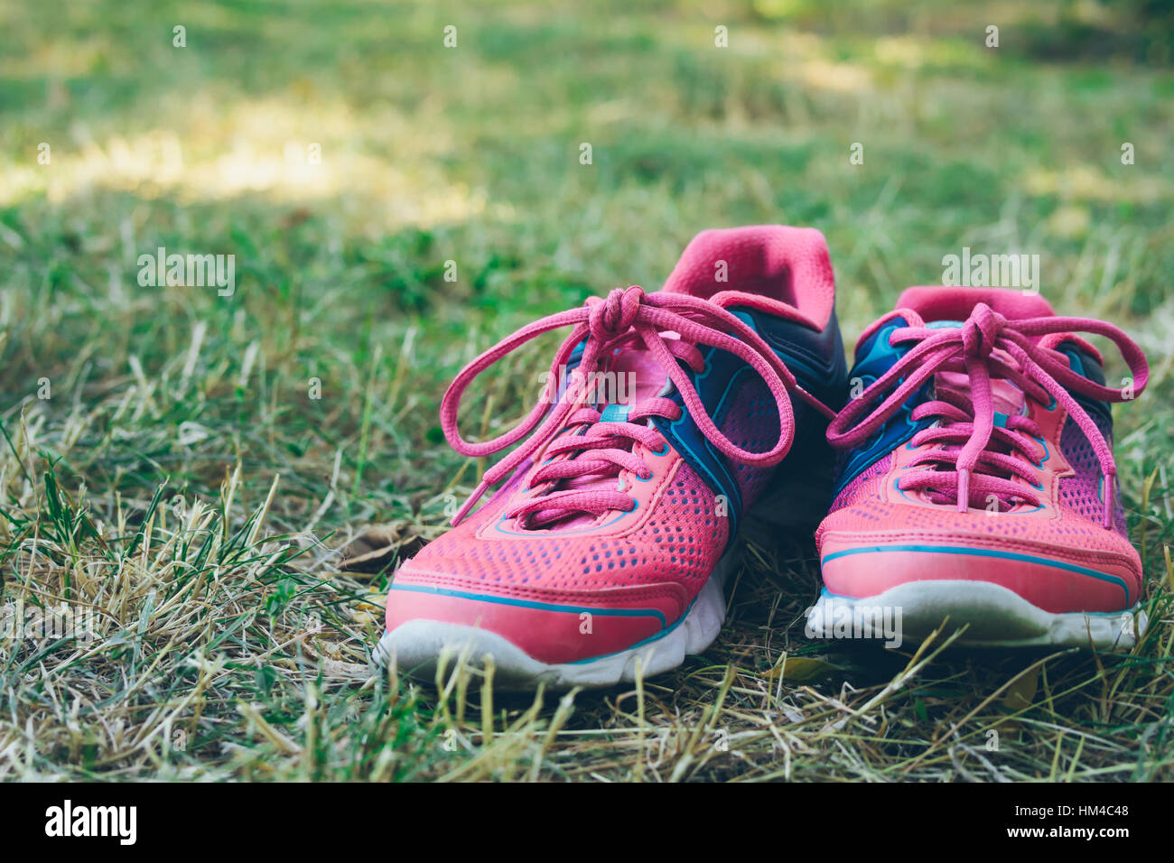 Rosa e blu sneakers su un prato verde. Riposo nel parco senza scarpe Foto  stock - Alamy