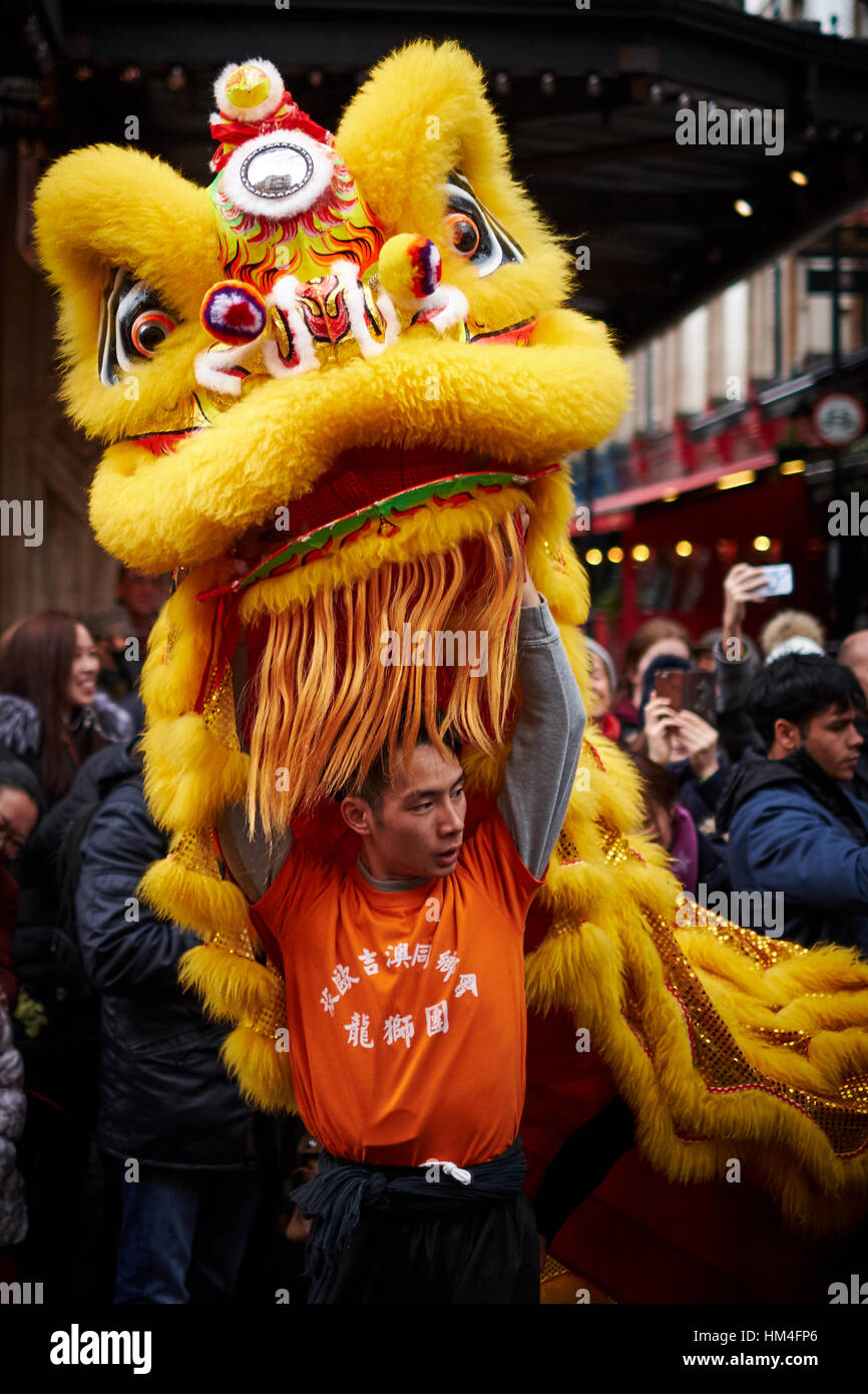 Ballerino maschio con un leone giallo costume prendendo parte ad un nuovo anno cinese parade. Foto Stock