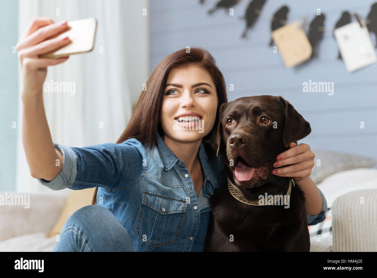 Elegante signora allegra e il suo animale domestico in posa per un colpo Foto Stock