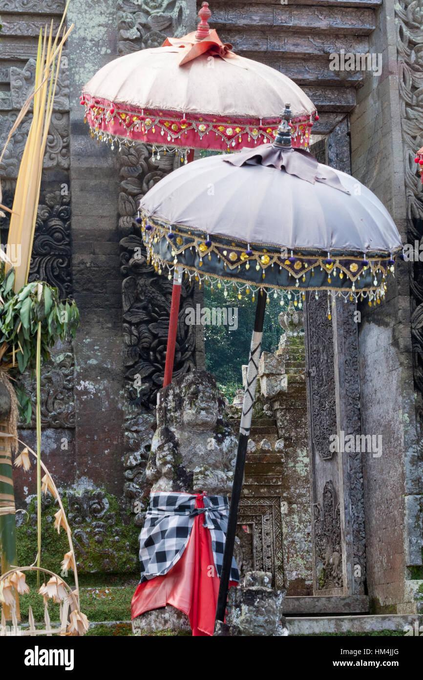 Ombrelli cerimoniali e santuario al di fuori di un tempio indù di Bali, Indonesia Foto Stock