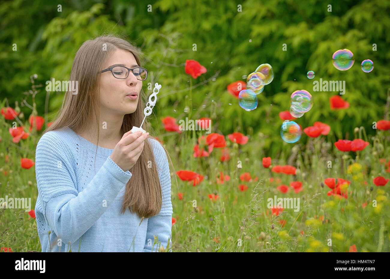 Ritratto di giovane ragazza con bolle di sapone in foresta Foto Stock