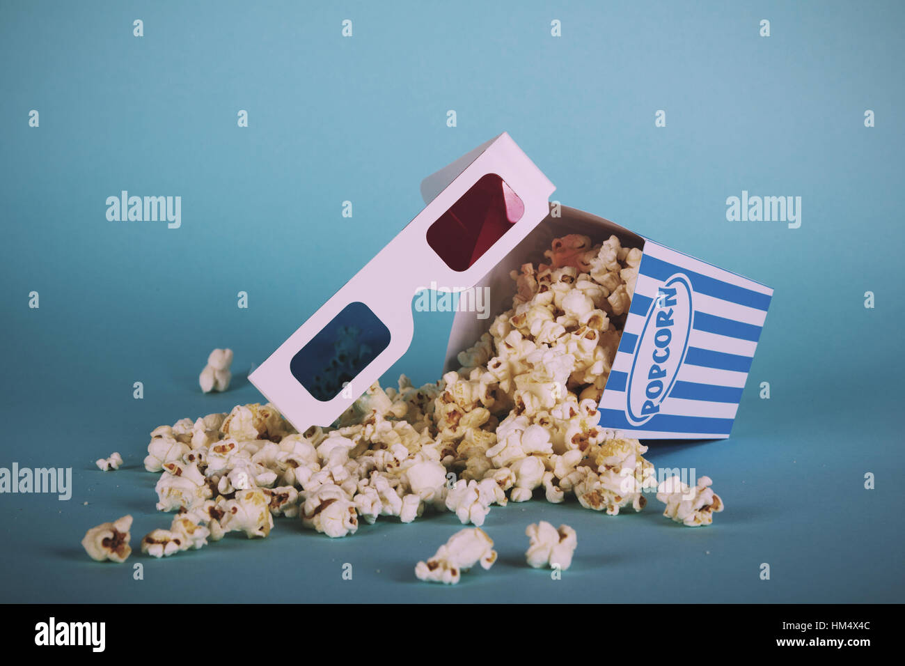 La benna di popcorn contro uno sfondo blu vintage filtro retrò. Foto Stock