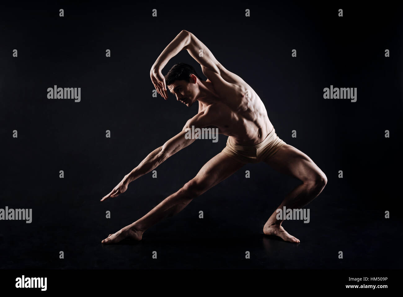 Athletic uomo fare yoga in colorati di nero studio Foto Stock