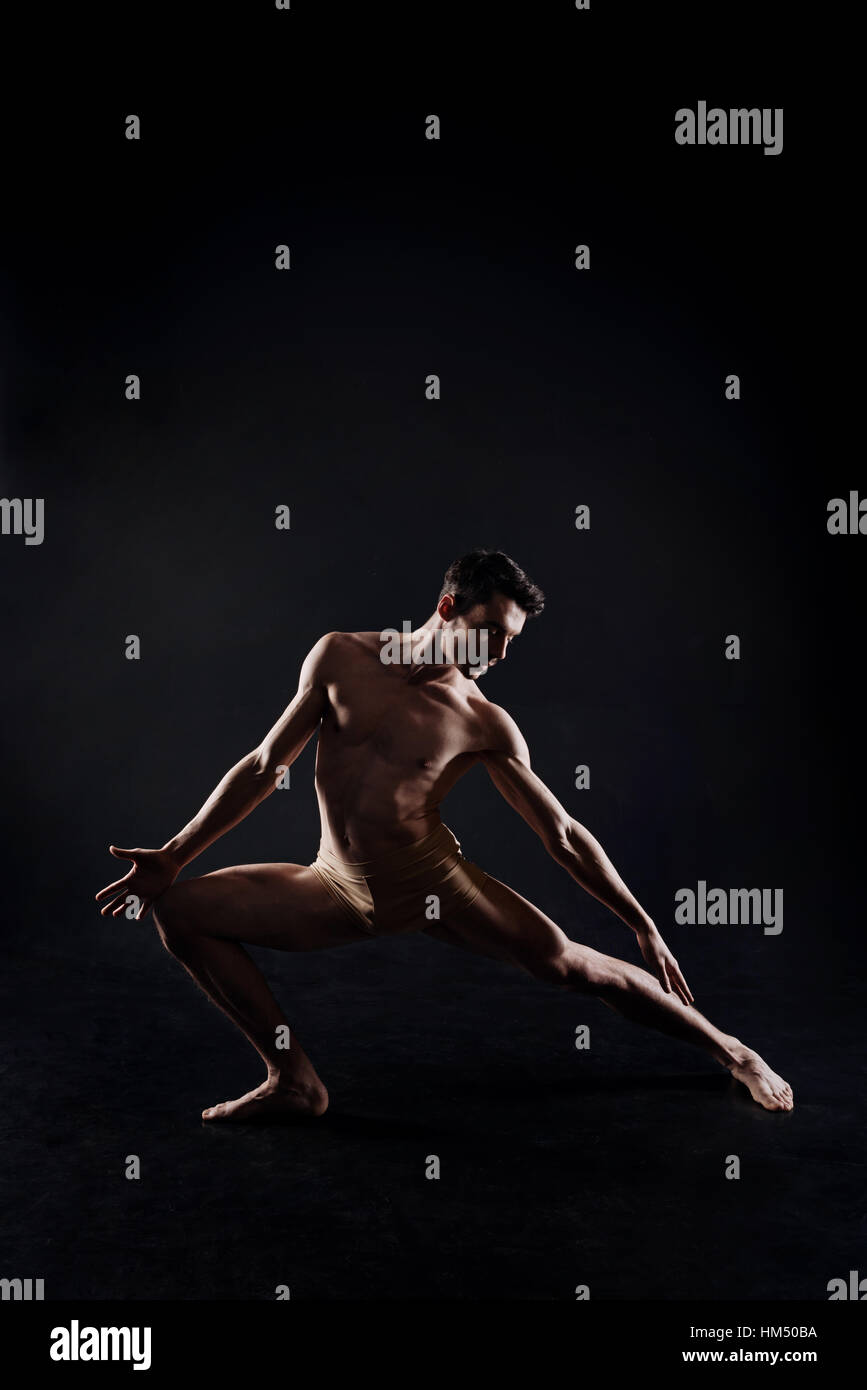 Atleta flessibile stretching in studio Foto Stock