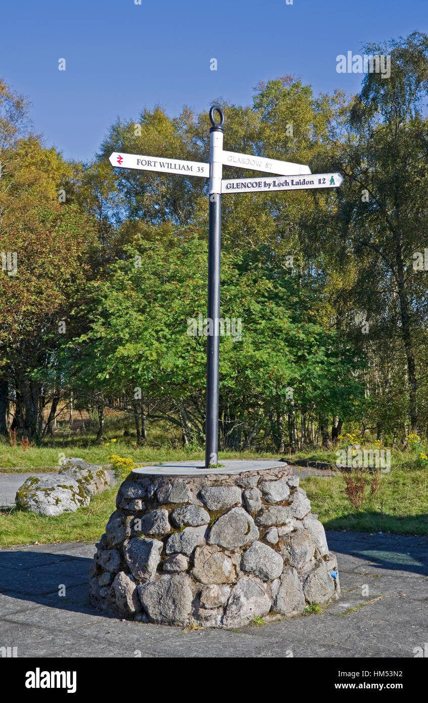 Cartello montato su zoccolo in pietra al di fuori della stazione di Rannoch, Perthshire, Highlands scozzesi, che mostra le destinazioni che possono essere raggiunte da questo punto. Foto Stock