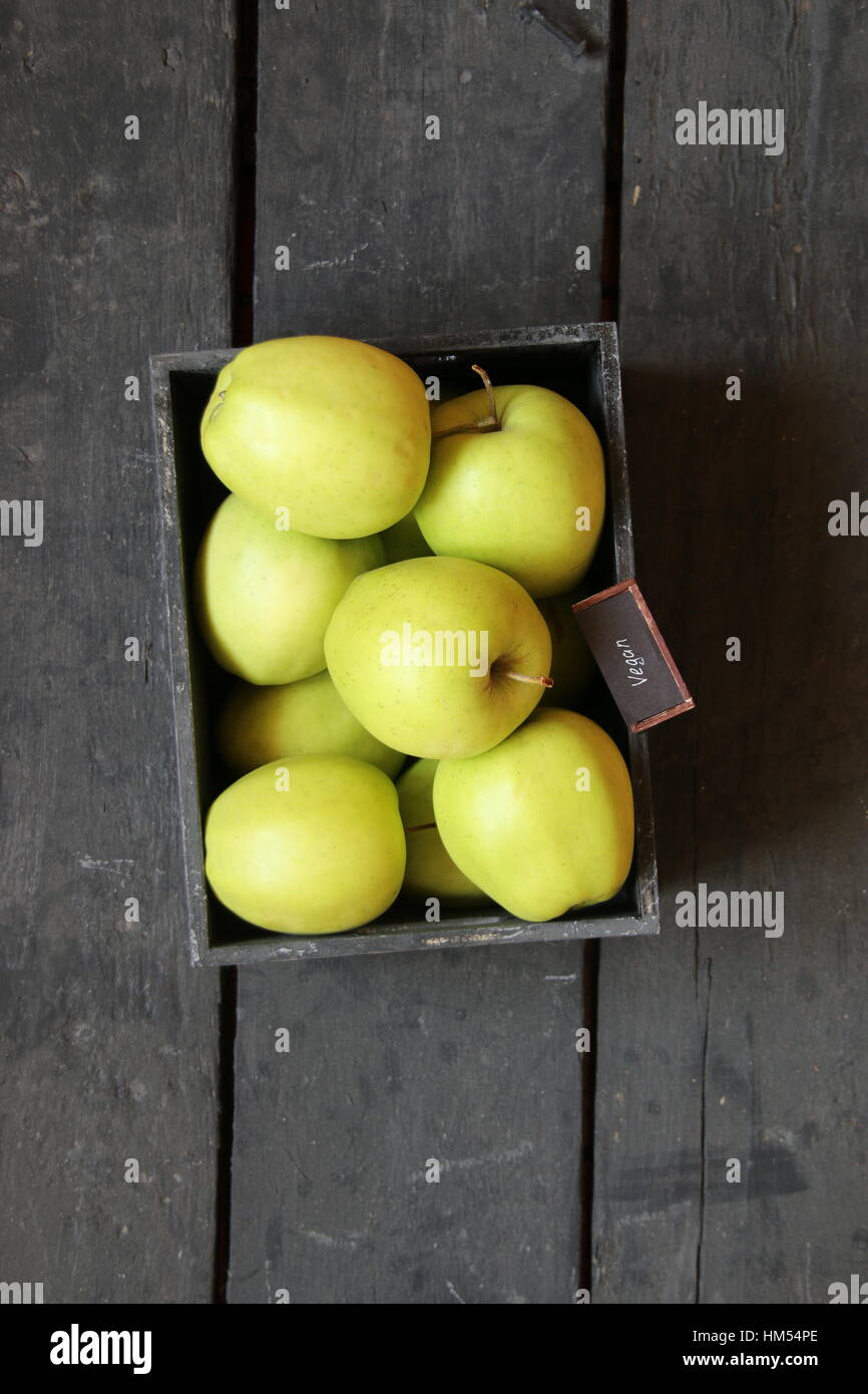 Cibo vegan idea, mela verde su un tavolo e tag Foto Stock