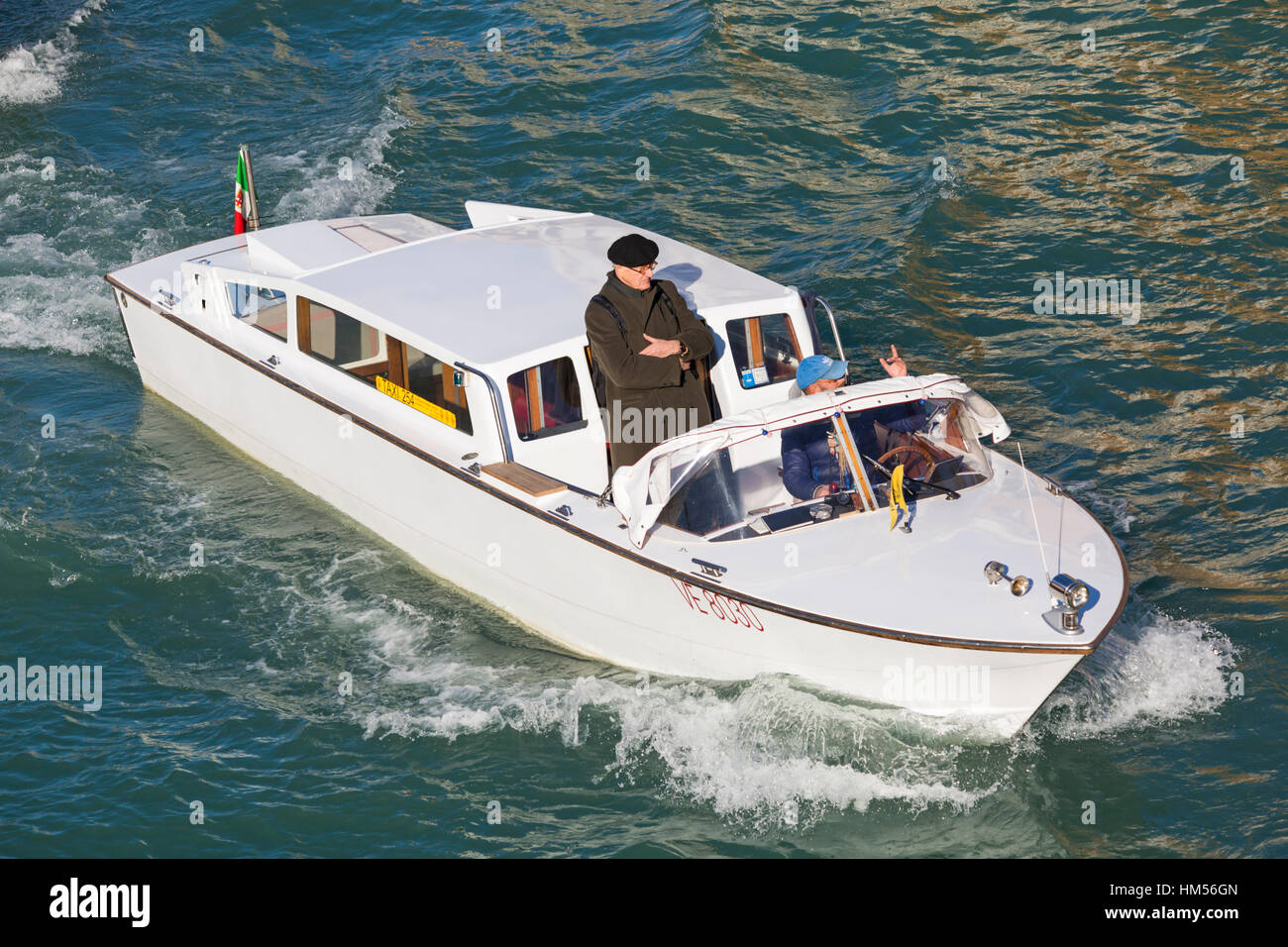 L'uomo facendo un giro sul water taxi a Venezia, Italia nel mese di gennaio Foto Stock