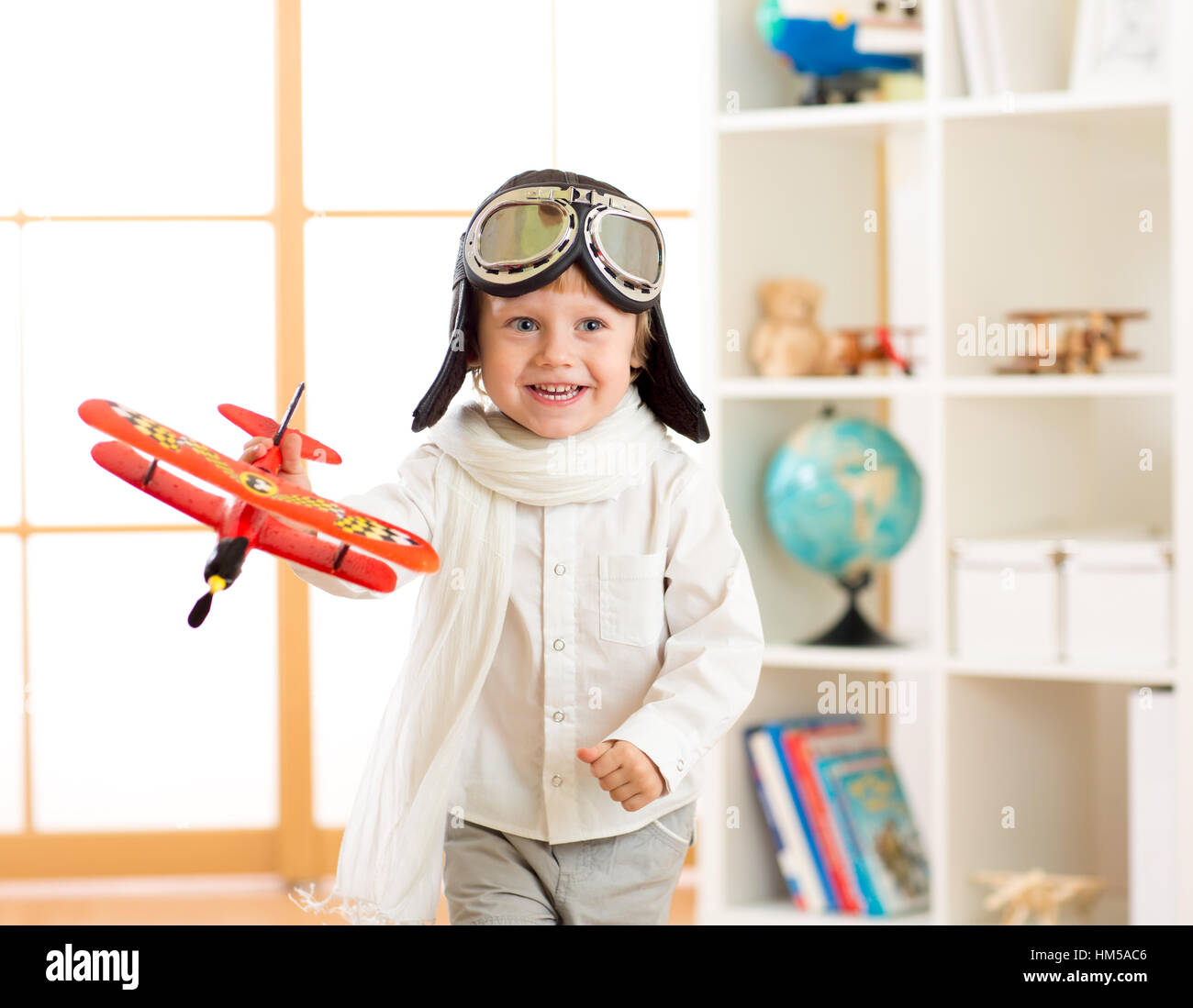 Bambino felice ragazzo giocare in aereo in ambienti interni Foto Stock