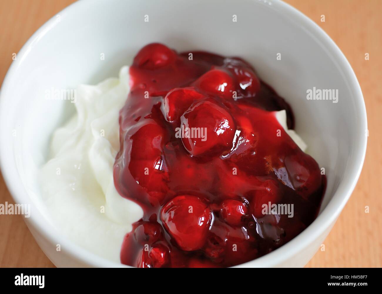 Bianco crema di yogurt con bacche rosse frutta nella ciotola bianco. Foto Stock