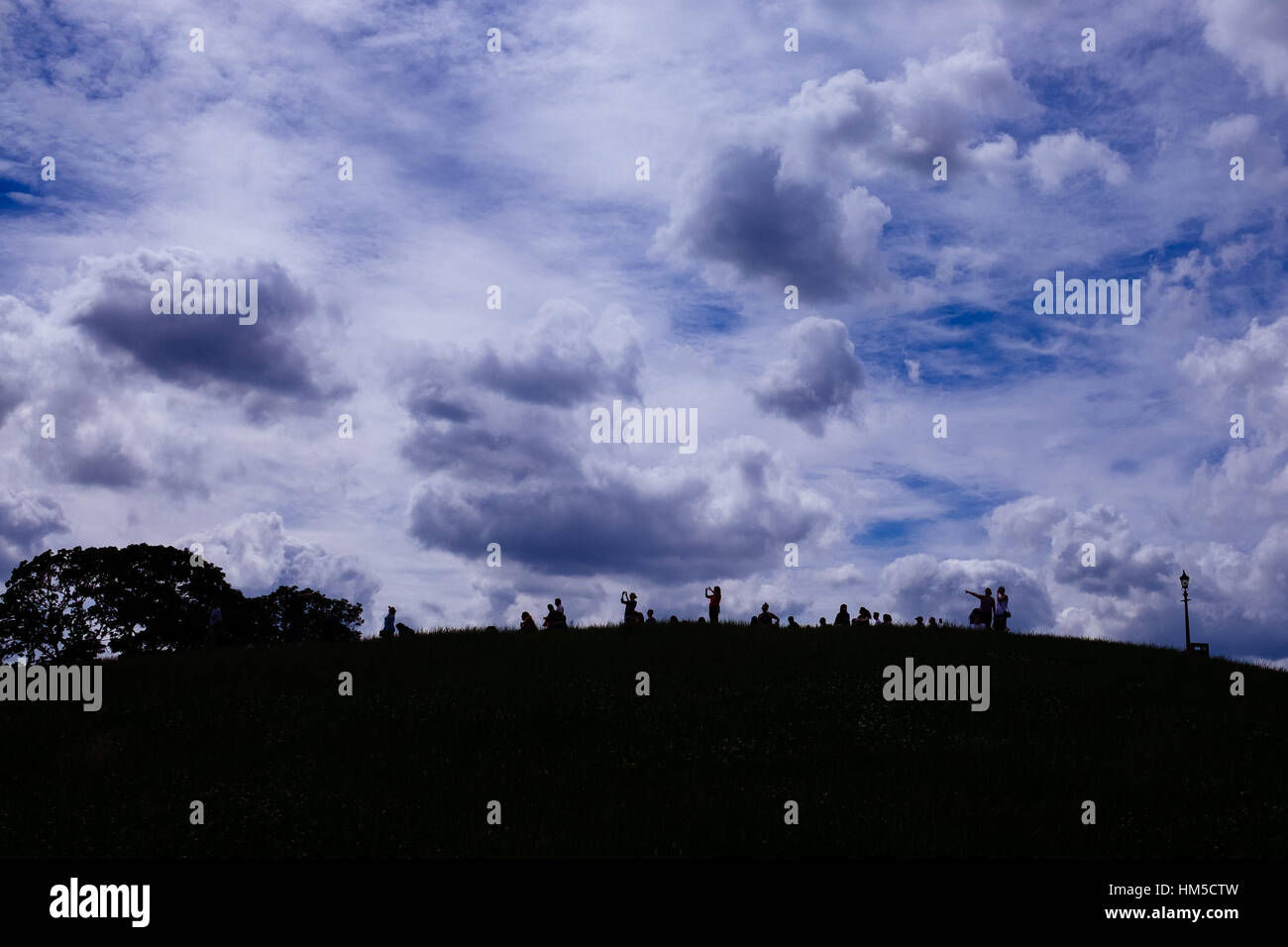 Primrose Hill cloudscape con silhouette di persone Foto Stock