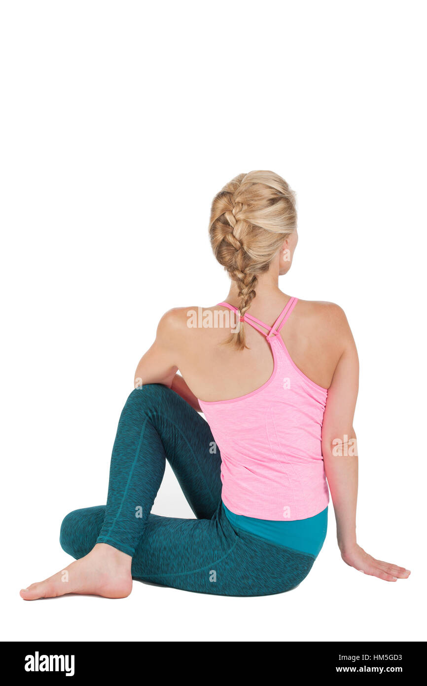 Corpo laterale vista di profilo di una donna bionda di mezza età nella posizione di Yoga seduta flessione in avanti (Paschimothanasana) contro w Foto Stock