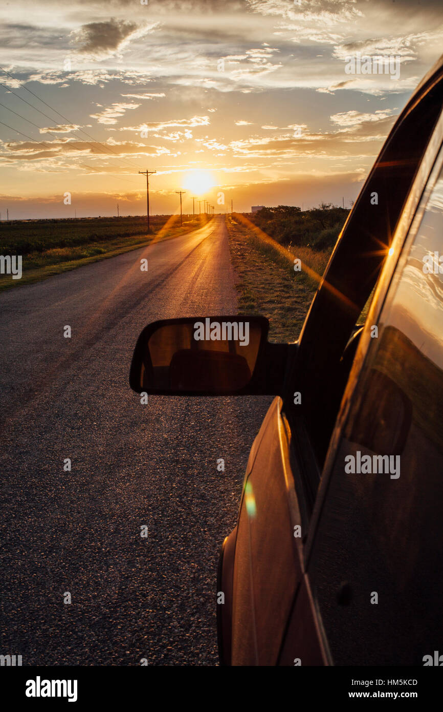 Close-up di retrovisore della vettura contro il cielo durante il tramonto Foto Stock