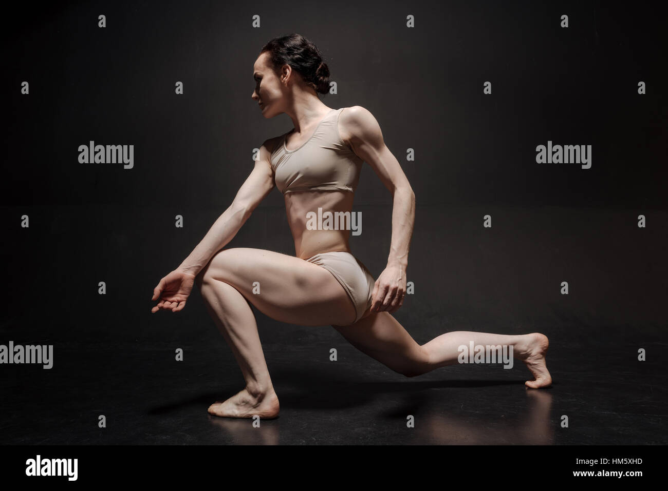 Fiducioso giovane ballerino che agiscono nel bianco studio Foto Stock