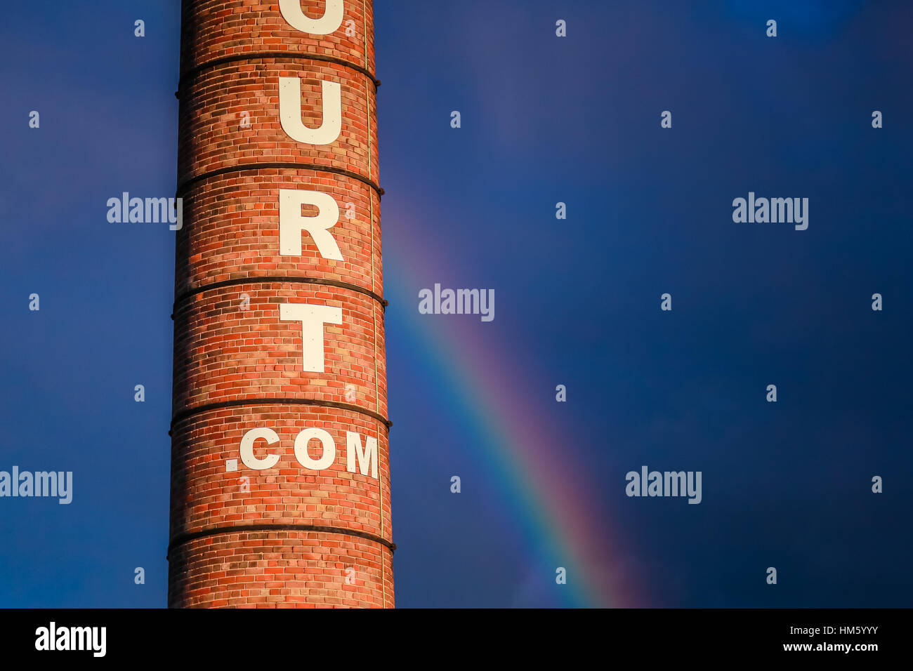 Un alto camino vittoriano con un arcobaleno e nuvole dietro Foto Stock