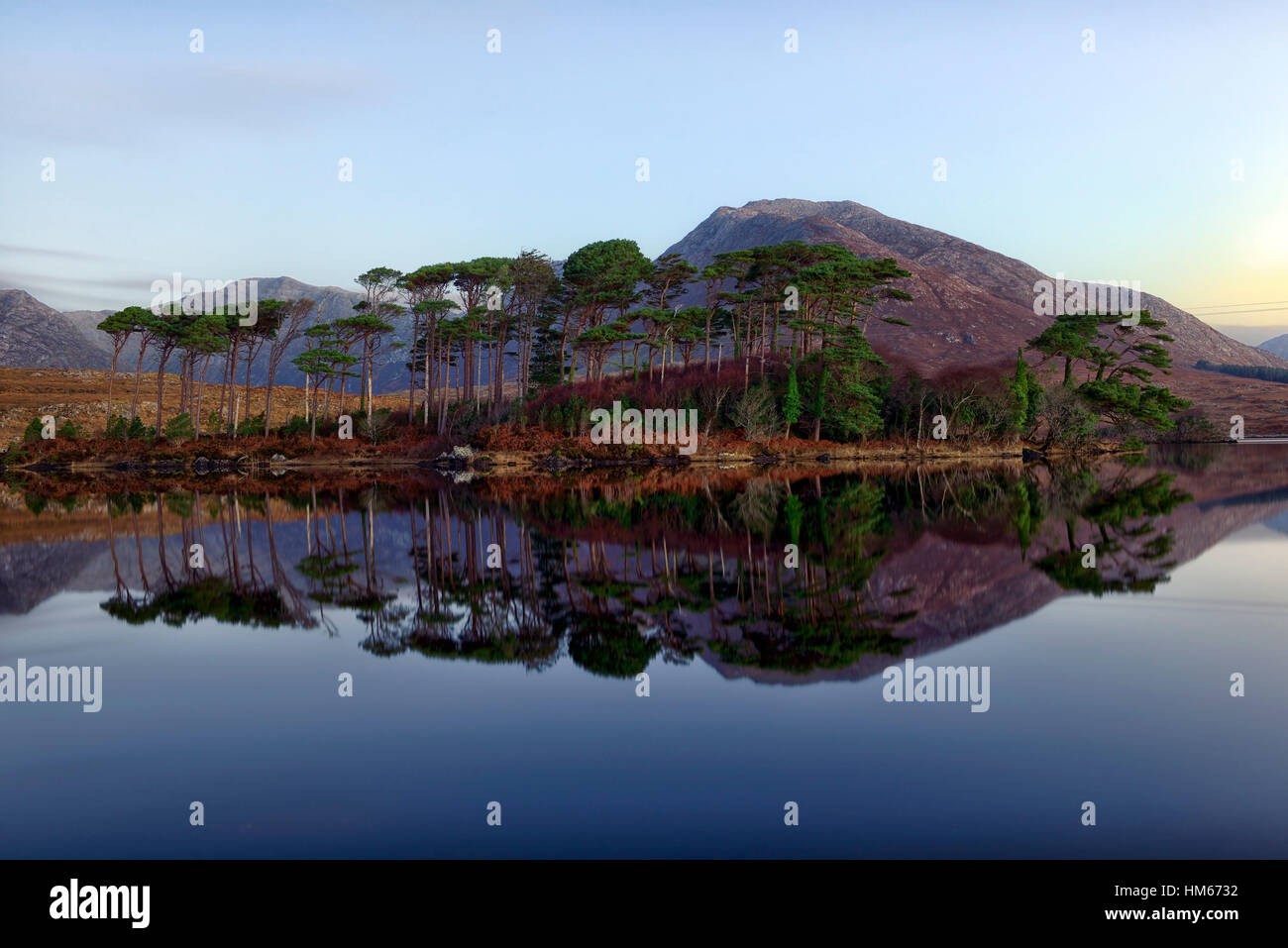Il Lough Derryclare lake Connemara Pine Island montagne selvatica modo atlantico Ovest dell Irlanda specchio riflette ancora la calma Foto Stock